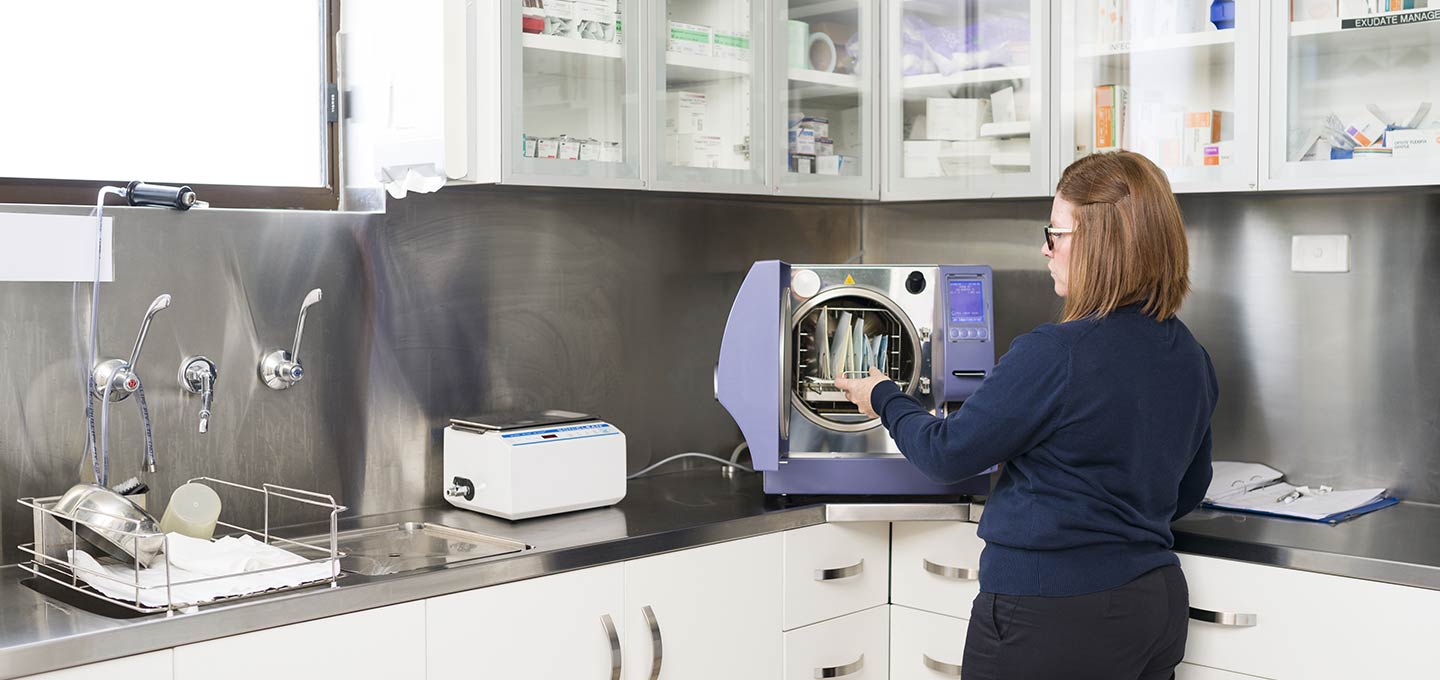 A nurse loading a steriliser.